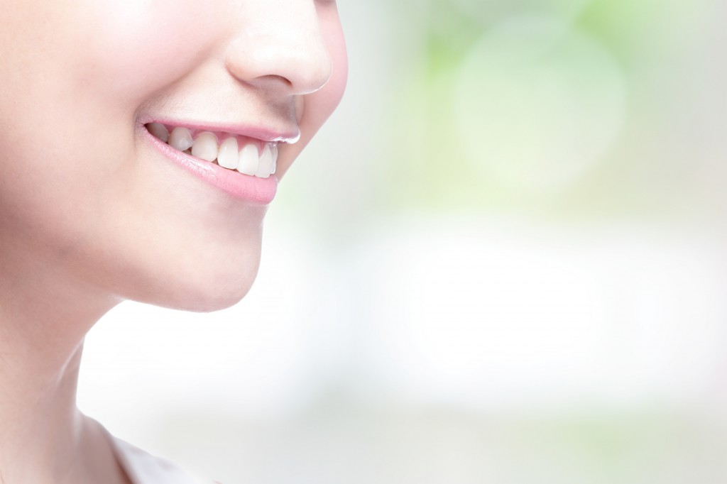 Beautiful young woman health teeth close up and charming smile. with green background, asian beauty